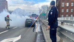 Malbork. Policjanci pomagali ugasić płonący samochód na moście.