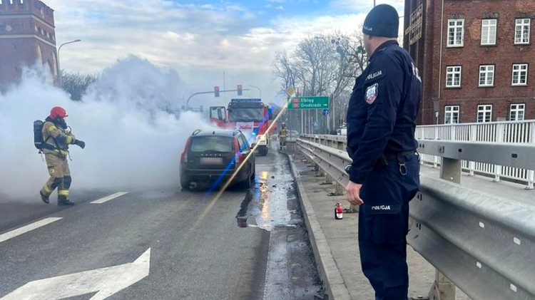 Malbork. Policjanci pomagali ugasić płonący samochód na moście.